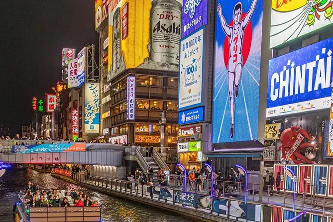 A covered Wonder Cruise boat on the Dotonbori River passing under a bridge during an Osaka river cruise tour