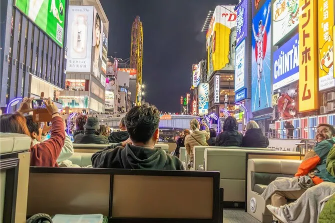 A small walking tour group in Dotonbori's backstreets before boarding an Osaka river cruise at the end of the experience