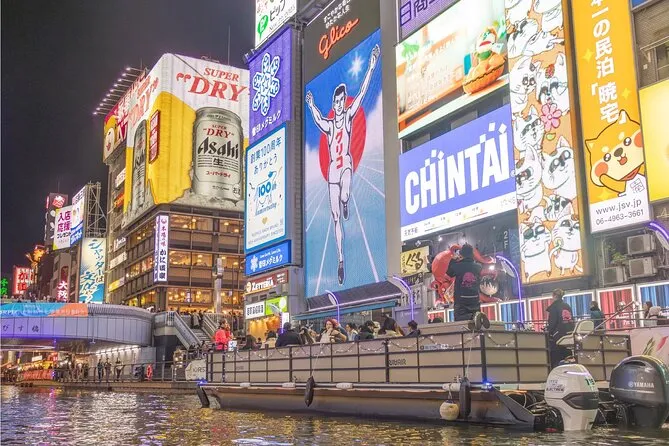 Tour group exploring Namba's vibrant entertainment district at night on an Osaka Kickstart city experience tour